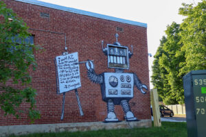 Robot mural painted on the side of a brick building