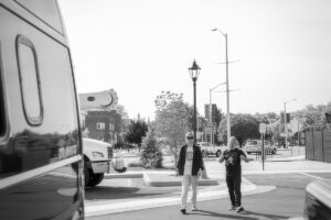 Black-and-white streetscape with pedestrians and decorative streetlamps